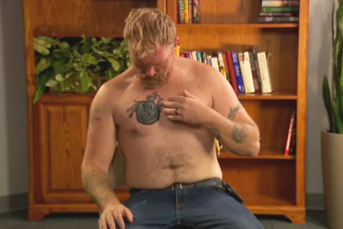 Graham Platner, a Democratic candidate for U.S. Senate, points to a cover-up tattoo that had previously been an image recognized as a Nazi symbol.