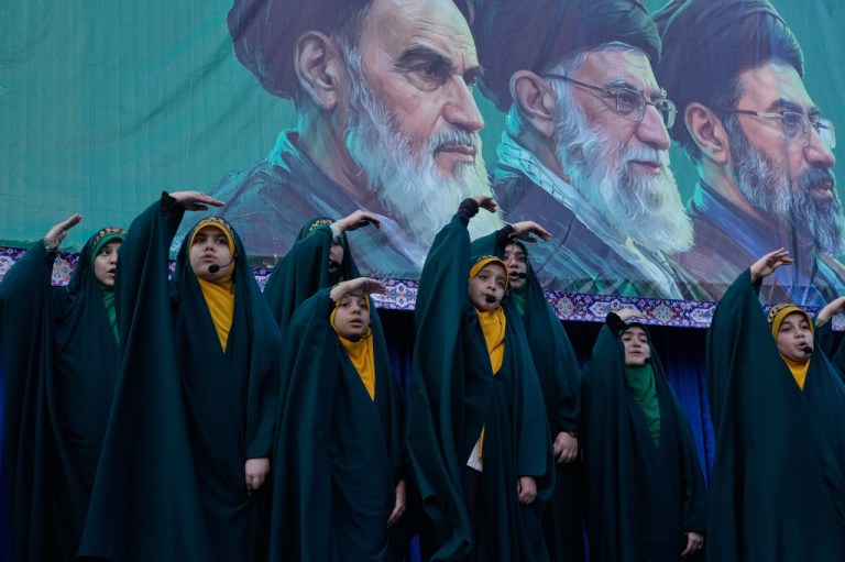 Children sing in front of portraits of ayatollahs