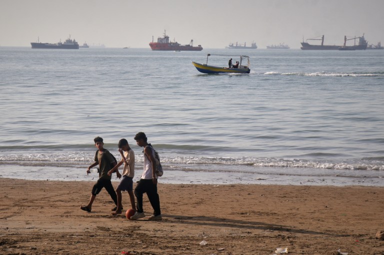 Children walk past the Strait of Hormuz.
