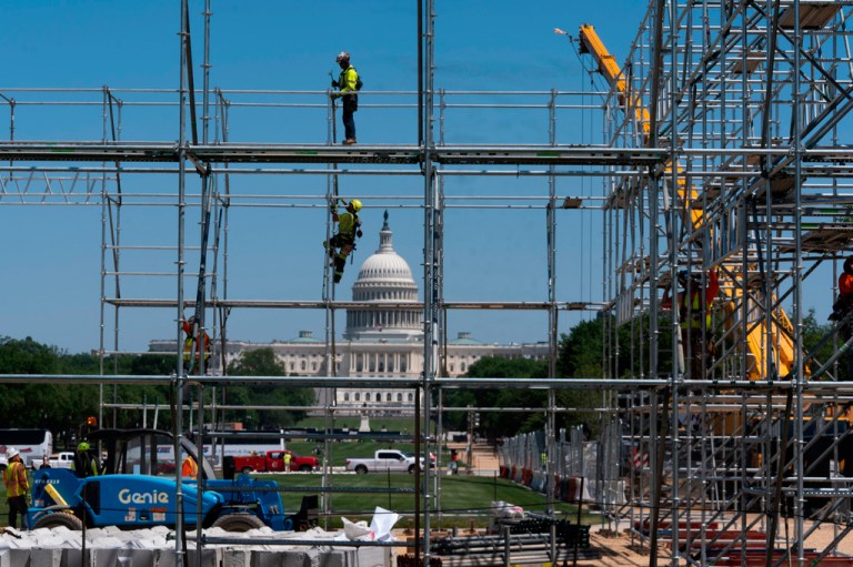 Workers erect scaffoldings as they begin construction on the National Mall for the Great American State Fair.