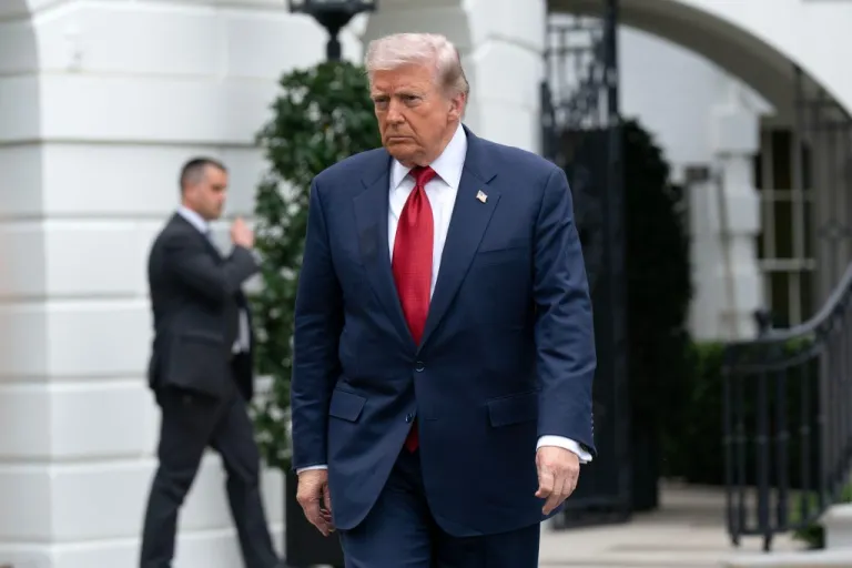 President Donald Trump walks to speak with reporters.