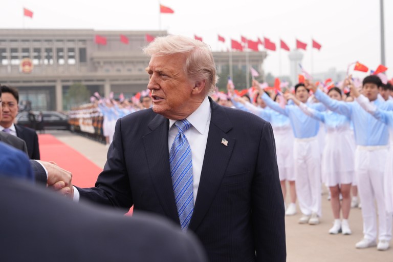 President Donald Trump is greeted by an official before boarding Air Force One, Friday, May 15, 2026, at Beijing Capital International Airport in Beijing. (AP Photo/Mark Schiefelbein)