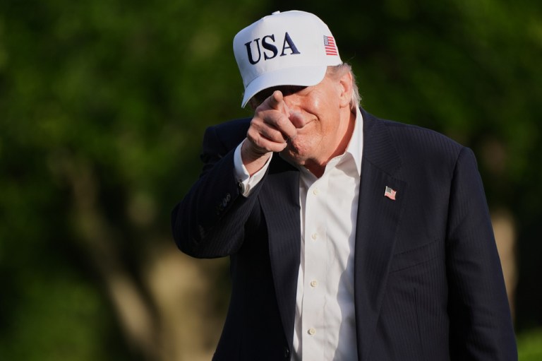 President Donald Trump gestures to reporters.