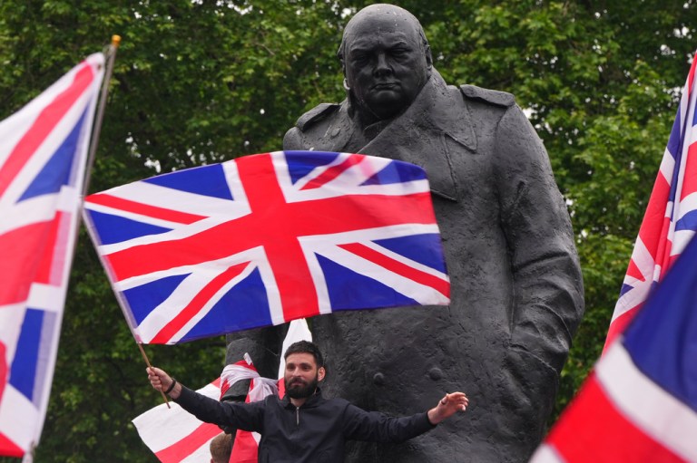 Protesters wave flags at the Winston Churchill statue during the Unite the Kingdom march in London, Saturday, May 16, 2026.(AP Photo/Kirsty Wigglesworth)