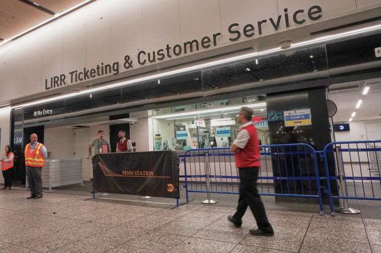 Workers stand near the Long Island Raill Road ticketing counter in New York's Penn Station, Tuesday, May 19, 2026.