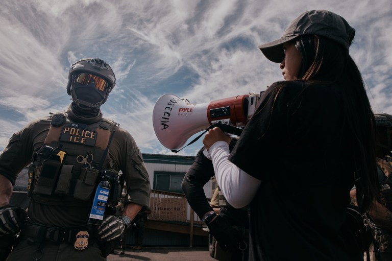 A protester plays music in front of a masked ICE agent outside the Delaney Hall detention during a protest against the transfer of detainees on Tuesday, May 26, 2026, in Newark, N.J. (AP Photo/Andres Kudacki)