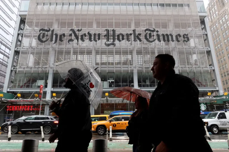 People walk past the front of the New York Times building.