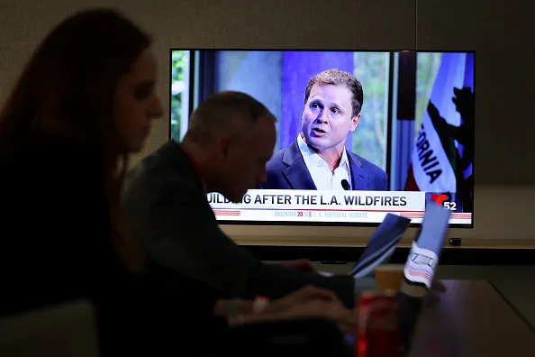 Los Angeles, CA - MAY 06, 2026: Spencer Pratt is shown on a television while journalists work during the 2026 Los Angeles Mayoral debate at Skirball Cultural Center on Wednesday, May 6, 2026 in Los Angeles, CA.