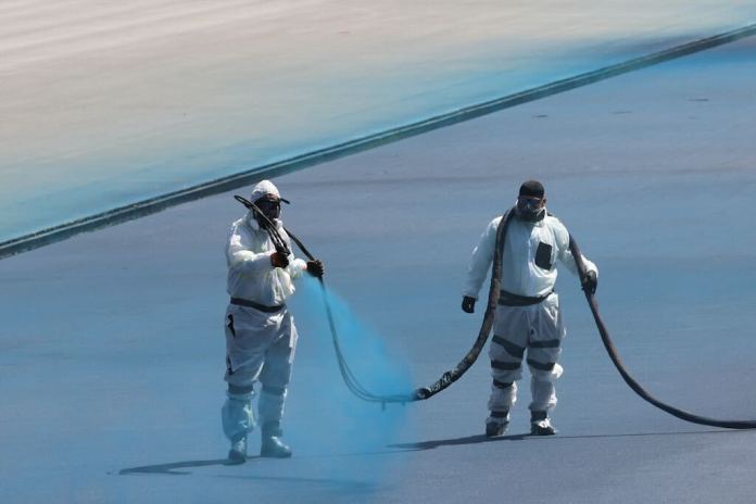 Workers spray blue lining on the Lincoln Memorial Reflecting Pool. (Photo by Graeme Jennings)