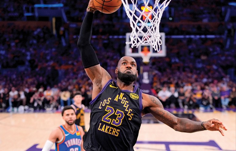 Los Angeles Lakers forward LeBron James dunks as Oklahoma City Thunder guard Ajay Mitchell watches during a second-round NBA basketball playoff game on May 11 in Los Angeles. (Mark J. Terrill/AP)