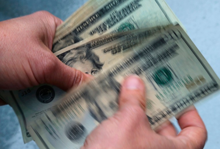 In this June 15, 2018, file photo, twenty dollar bills are counted.