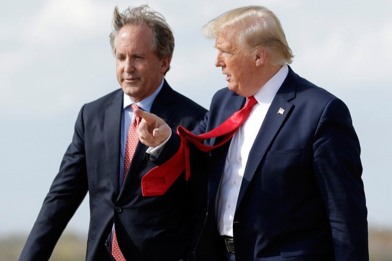 President Donald Trump walks with Texas Attorney General Ken Paxton, left, at Austin-Bergstrom International Airport.