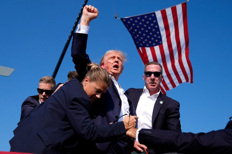 Donald Trump is surrounded by U.S. Secret Service agents after an assassination attempt at a campaign rally in Butler, Pennsylvania.