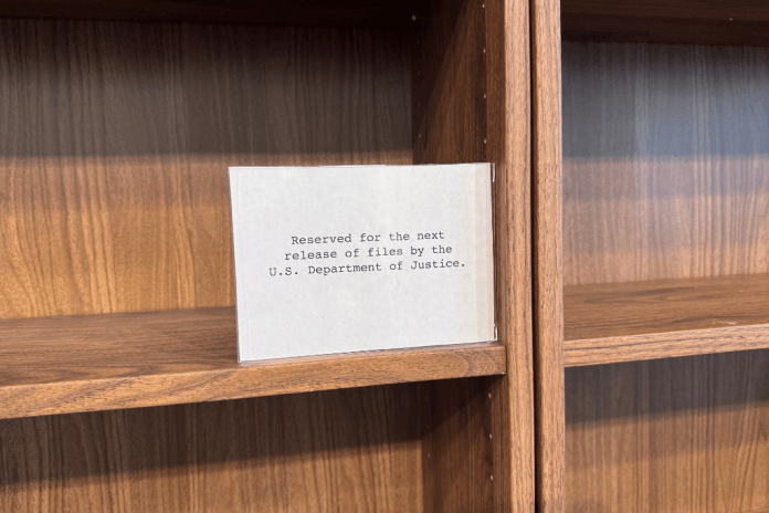A sign on a wooden shelf.