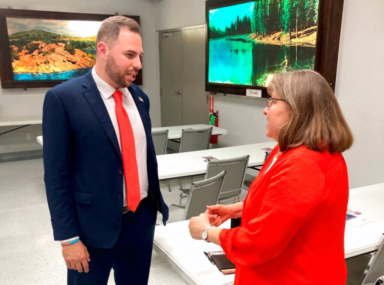 Republican U.S. Senate candidate Jackson Lahmeyer, a Tulsa-area pastor, speaks to Edmond resident Winona Heltzel on March 15, 2022, at the H&H Shooting Sports gun range during a meeting of the Oklahoma 2nd Amendment Association in Oklahoma City. The pro-firearms association was little-known a decade ago but has grown into a formidable political player at the state Capitol.