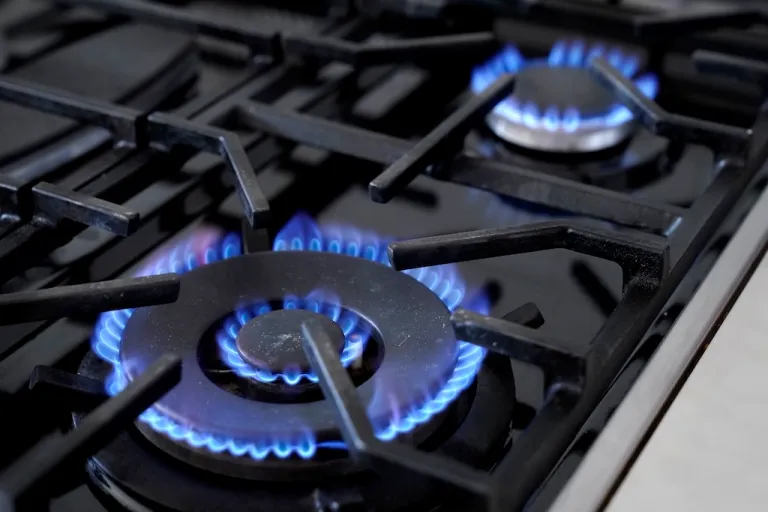 Flames emerge from burners on a natural gas stove, Wednesday, June 21, 2023, in Walpole, Massachusetts.