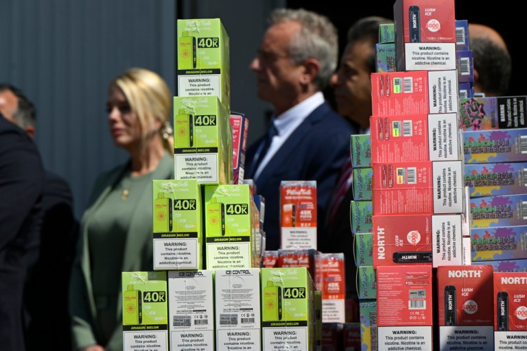 U.S. Attorney General Pam Bondi and U.S. Secretary of Health and Human Services Robert Kennedy Jr. look on while vape products are on display in the foreground during a press conference in Bensonville, Ill., Wednesday, Sept. 10, 2025, in Chicago. (AP Photo/Paul Beaty)
