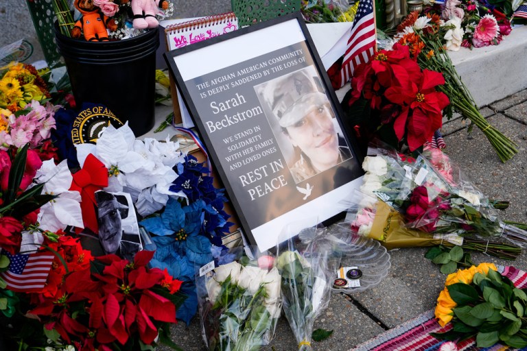 Flowers, challenge coins and other items lay near a photograph of U.S. Army Spc. Sarah Beckstrom at a makeshift memorial.