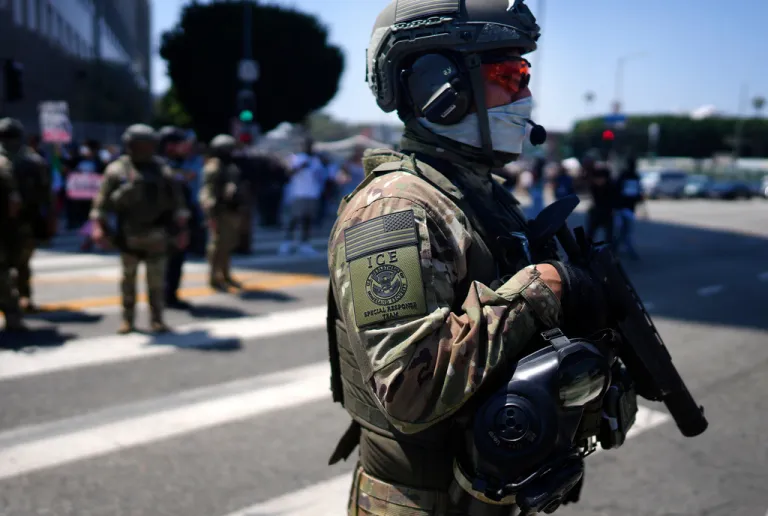 An ICE Special Response Team member stands guard outside the Metropolitan Detention Center.