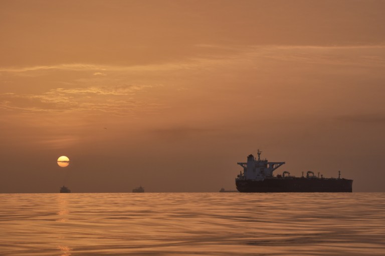 The sun rises behind tankers anchored in the Strait of Hormuz off the coast of Qeshm Island.