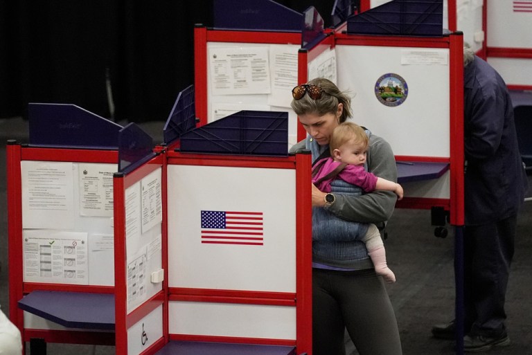 Lindsay Robinson, with daughter Scottie, fills out her ballots in the Maine Primary, Tuesday, June 9, 2026, in Augusta, Maine. (AP Photo/Robert F. Bukaty)