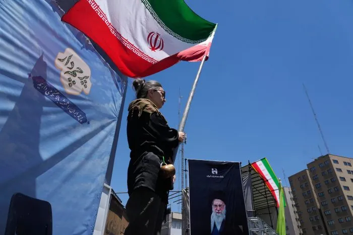 A woman waves an Iranian flag during a pro-government campaign in Tehran on June 15, 2026.