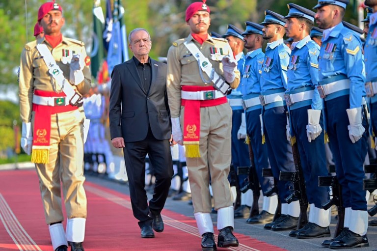 Iran's President Masoud Pezeshkian, center, reviews an honor guard during a welcome ceremony in Islamabad, Pakistan, on Tuesday, June 23, 2026.