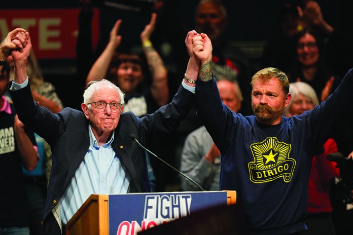 Graham Platner, Democratic candidate for U.S. Senate, and Sen. Bernie Sanders, left, join hands at an event in Orono, Maine, Sunday, May 24, 2026. (AP Photo/Robert F. Bukaty)
