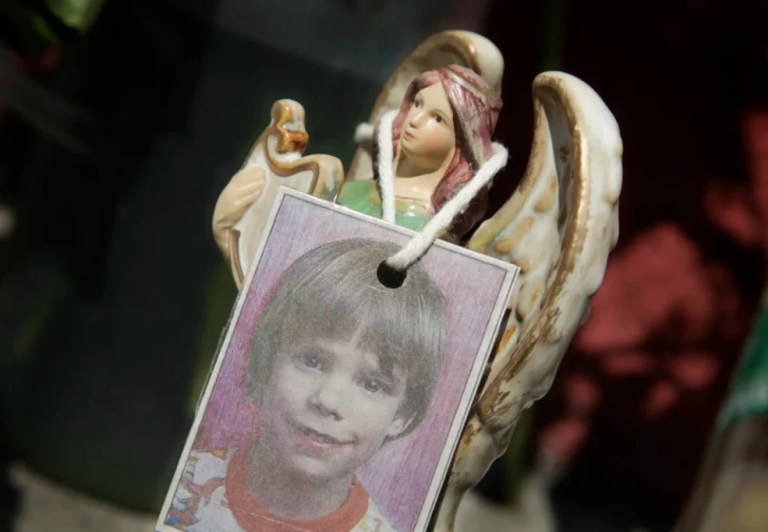 A photograph of Etan Patz hangs on an angel figurine.