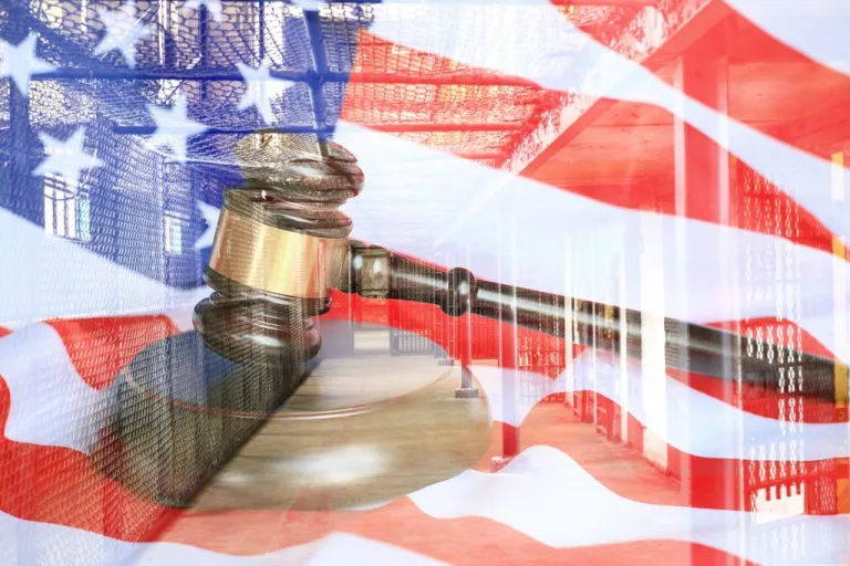 An American flag waves behind a lawyer's gavel resting on its block. (Getty Images)