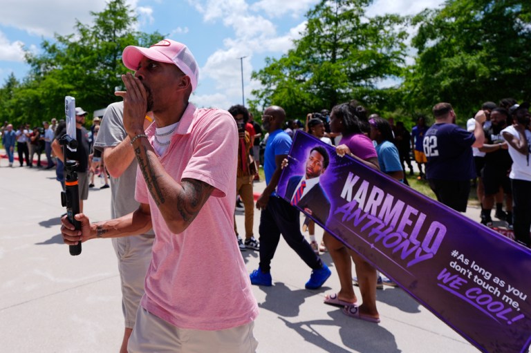 A person walks around announcing the guilty verdict in the Karmelo Anthony trial in front of the Collin County courthouse.