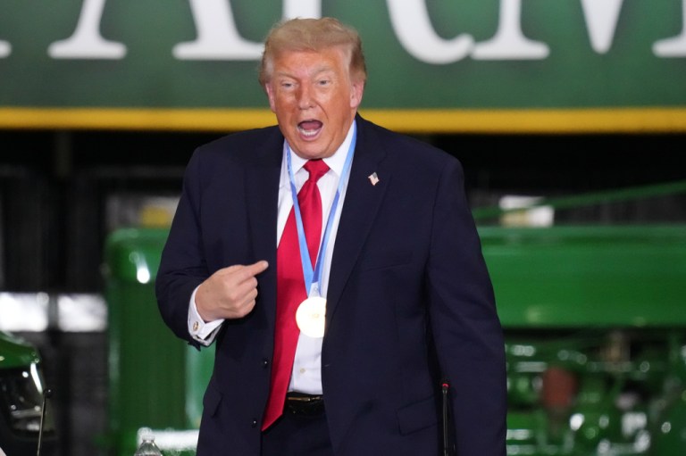 President Donald Trump wears a gold medal from Olympic speedskater Jordan Stolz.